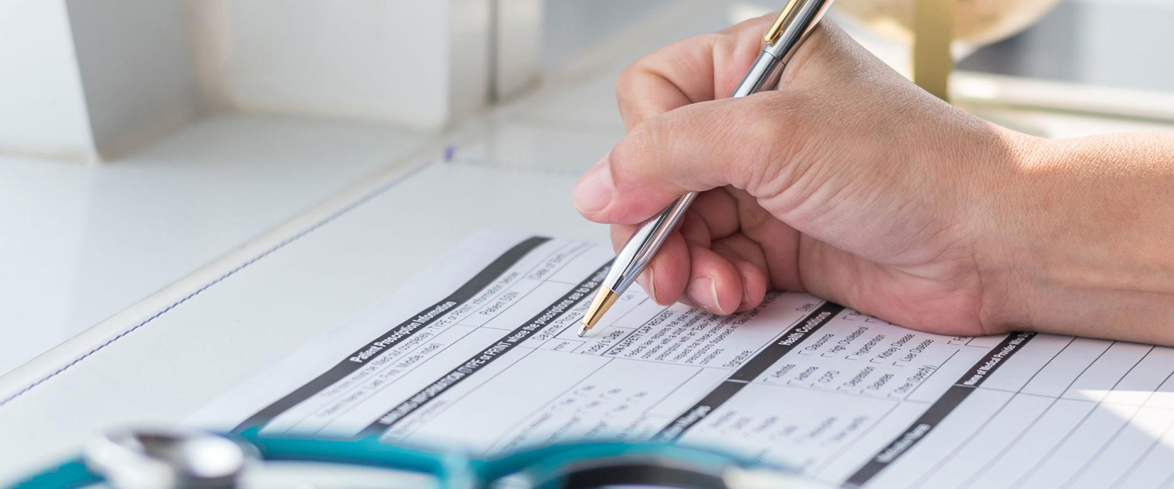 Doctor writing on medical health care record